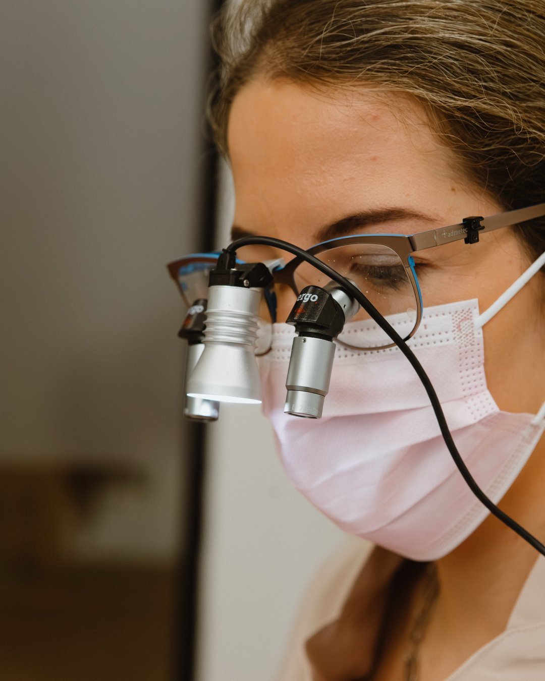 Odontóloga con lupas de aumento preparando carillas con mínimo tallado en MOMA Estudio Dental, Albacete
